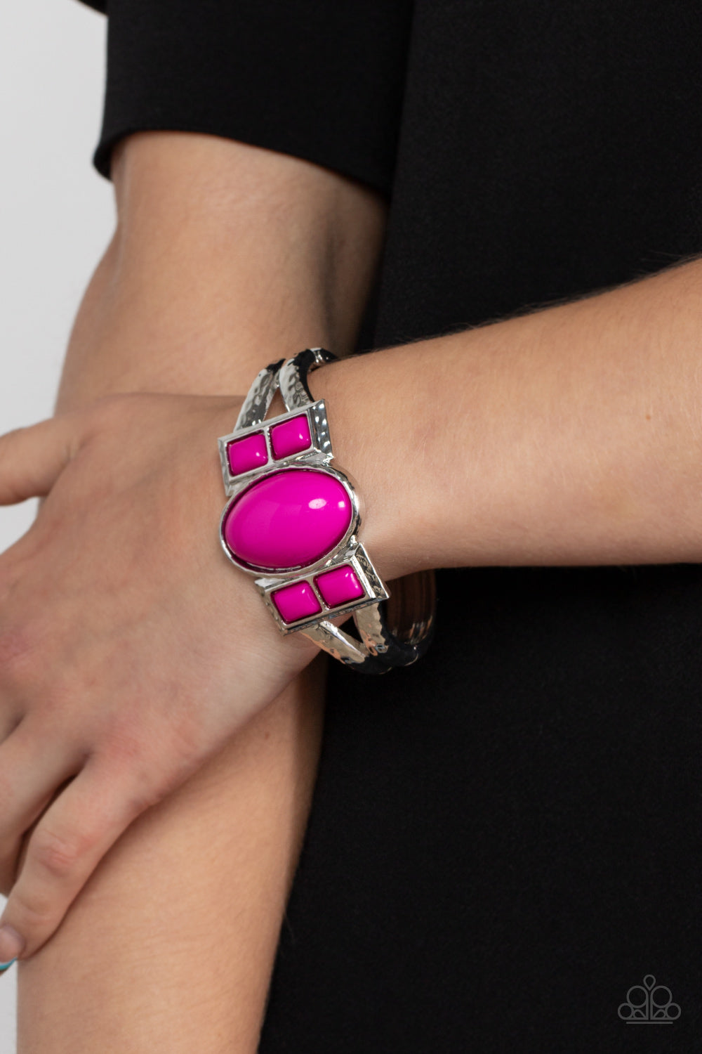 A Touch of Tiki Pink Hinge Bracelet - Paparazzi Accessories  An oversized oval Fuchsia Fedora bead is flanked by pairs of stacked Fuchsia Fedora square beads across the center of a hammered silver bangle-like bracelet, creating a bold pop of color atop the wrist. Features a hinged closure.  Sold as one individual bracelet.
