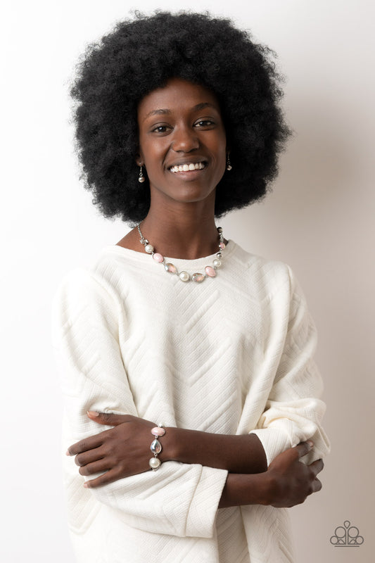 Nautical Nirvana Pink Necklace & Bracelet Set - Paparazzi Accessories A collection of classic white pearls, iridescent Pale Rosette beads, white emerald cut gems, and iridescent crystal-like teardrops dance below the collar for an ethereal display. Shiny silver frames encase each bead, adding a romantic vibe to the vintage inspired design. 