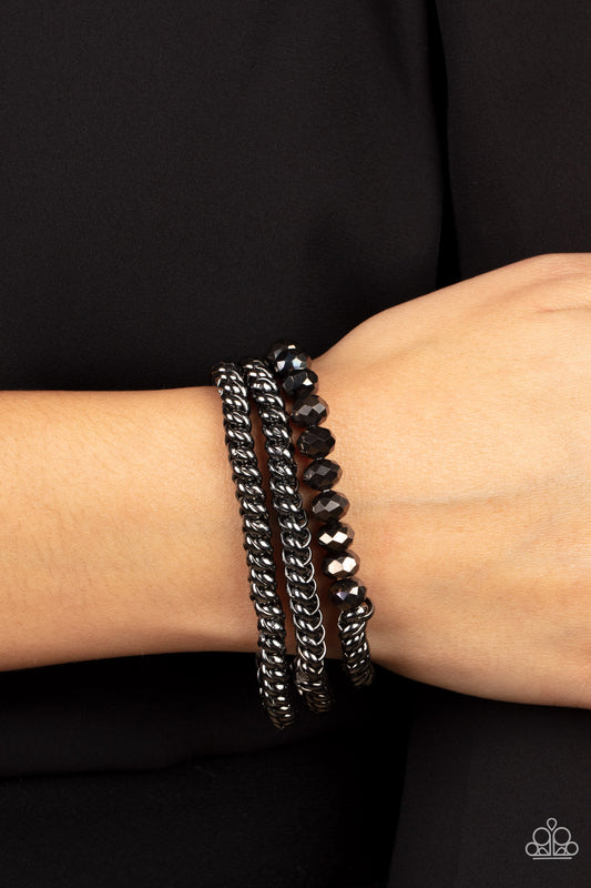 Gutsy and Glitzy Black Bracelet - Paparazzi Accessories  Threaded along stretchy bands, sections of hematite crystal-like beads and interlocking gunmetal chains layer around the wrist for a dash of glitzy grunge.  Sold as one set of three bracelets.