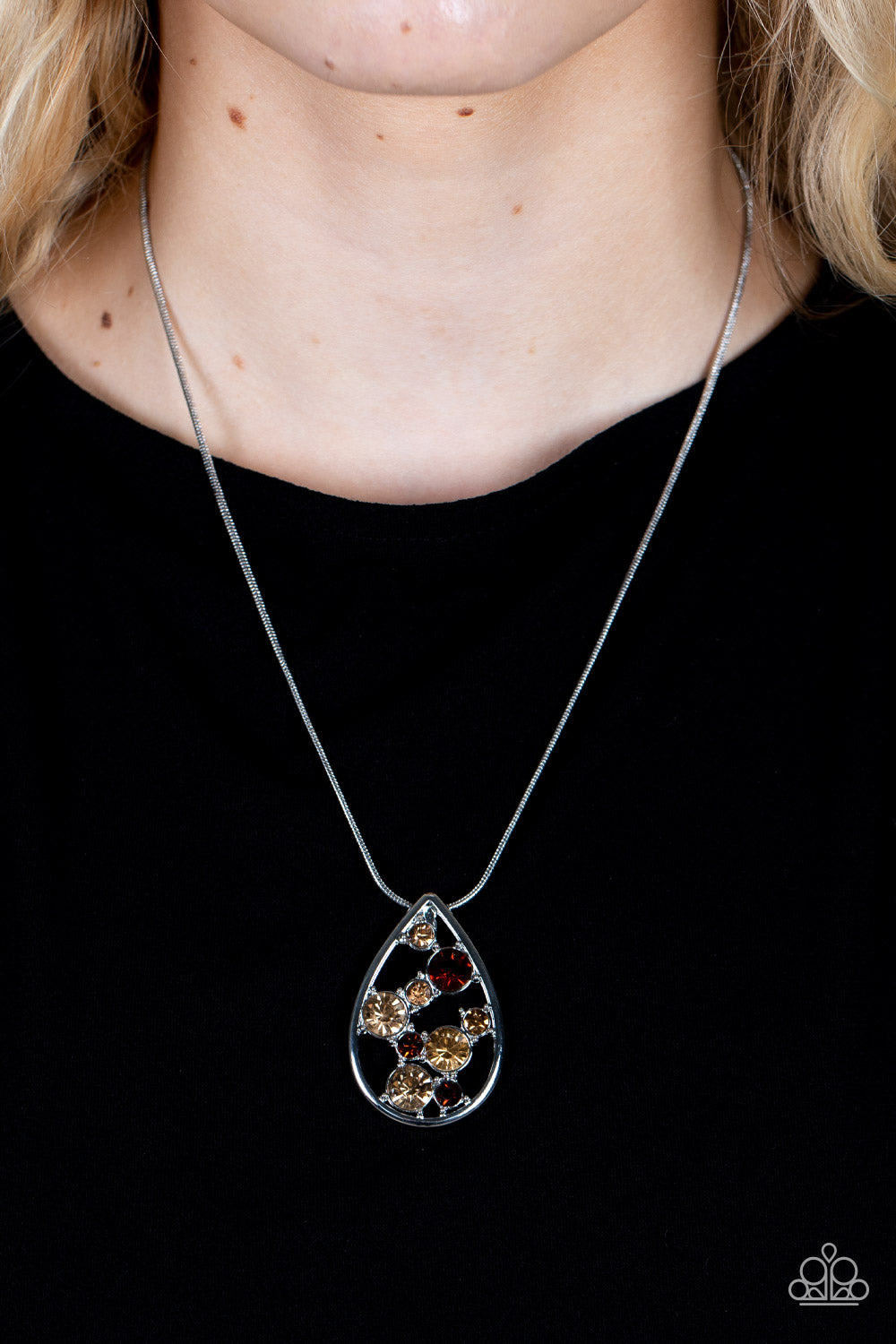 Seasonal Sophistication - Brown Item #P2RE-BNXX-277XX A bubbly collection of classic and golden topaz rhinestones coalesce inside an airy silver teardrop, resulting in an effervescently elegant pendant at the bottom of a rounded silver snake chain. Features an adjustable clasp closure.  Sold as one individual necklace. Includes one pair of matching earrings.