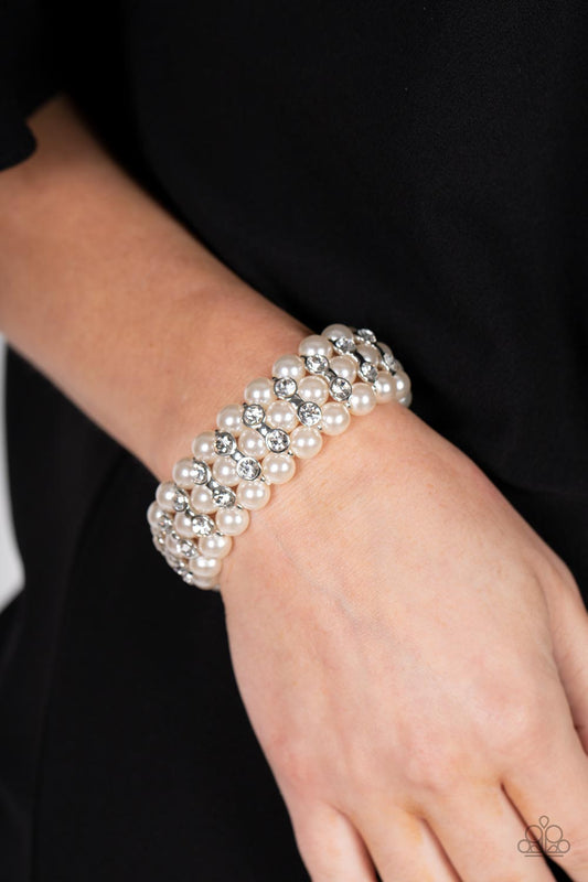 Eiffel Tower Elegance White Pearl Bracelet - Paparazzi Accessories  Stacked rows of bubbly white pearls alternate with white rhinestone encrusted silver frames along stretchy bands, adding a timeless twist to the traditional pearl palette.  Sold as one individual bracelet.
