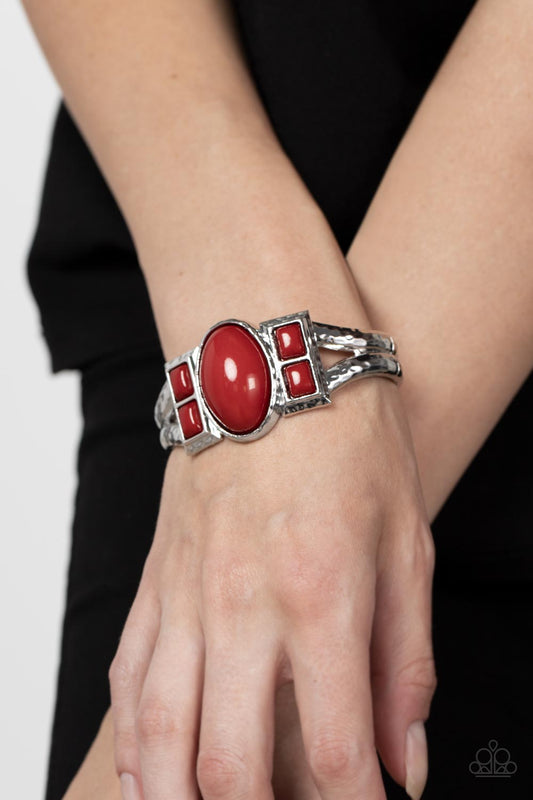 A Touch of Tiki Red Bracelet - Paparazzi Accessories  An oversized oval Fire Whirl bead is flanked by pairs of stacked Fire Whirl square beads across the center of a hammered silver bangle-like bracelet, creating a bold pop of color atop the wrist. Features a hinged closure.  Sold as one individual bracelet.