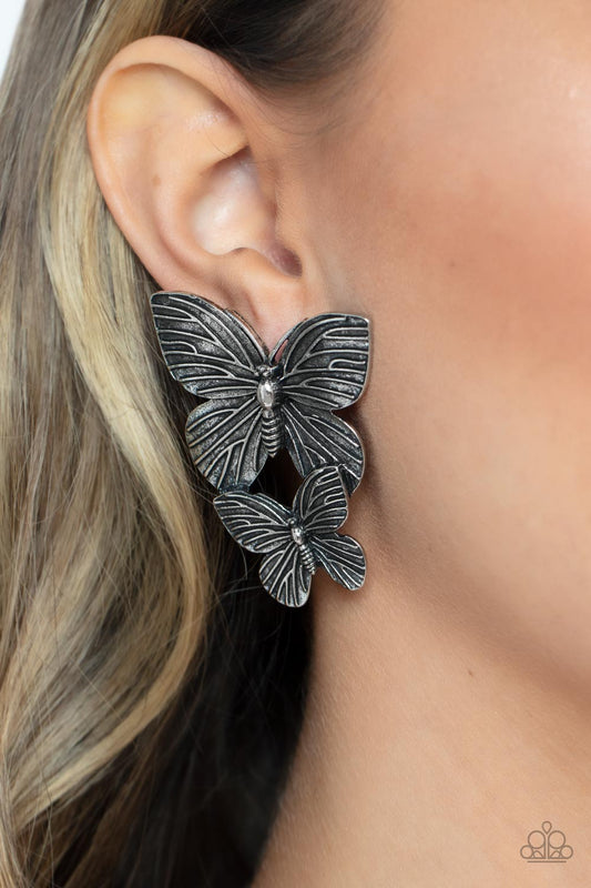 Blushing Butterflies Silver Earring - Paparazzi Accessories  Veined with lifelike textures, a pair of rustic silver butterflies flutters from the ear for a whimsical fashion. Earring attaches to a standard post fitting.  Sold as one pair of post earrings.