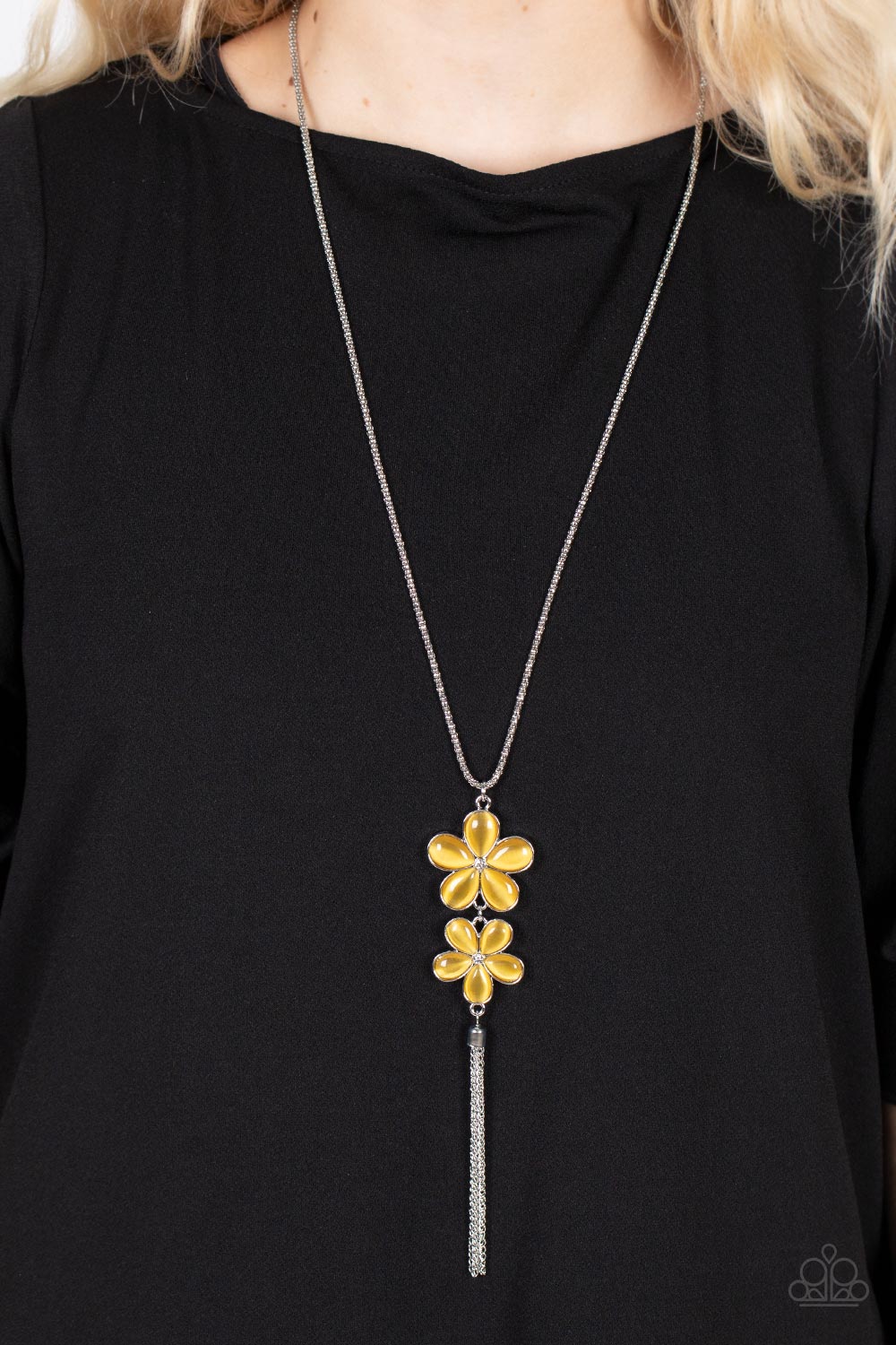 Perennial Powerhouse - Yellow Item #P2WH-YWXX-269XX Dotted with dainty white rhinestone centers, a pair of yellow cat's eye petaled flowers swing from the bottom of an extended silver popcorn chain. A silver chain tassel swings from the bottom of the enchanting display, adding playful movement to the floral centerpiece. Features an adjustable clasp closure.  Sold as one individual necklace. Includes one pair of matching earrings.