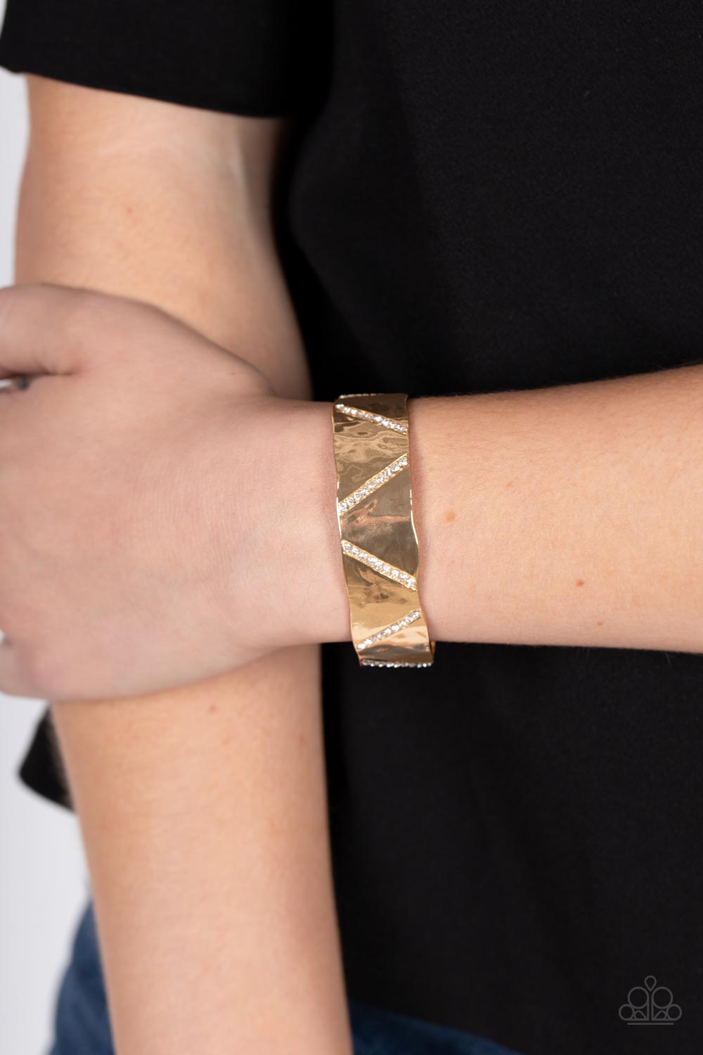Couture Crusher Gold Cuff Bracelet - Paparazzi Accessories Item #P9ED-GDXX-046XX Rows of glassy white rhinestones slant across the front of a gently hammered gold cuff that waves around the wrist, result in an edgy shimmer.  Sold as one individual bracelet.