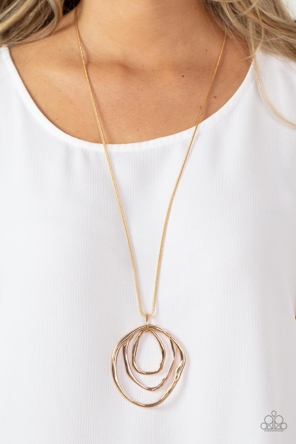 Revamped Relic - Gold Item #P2BA-GDXX-052XX A trio of mismatched warped gold and rose gold rings swing from the bottom of a glistening gold chain, creating an asymmetrically stacked pendant. Features an adjustable clasp closure.  Sold as one individual necklace. Includes one pair of matching earrings.