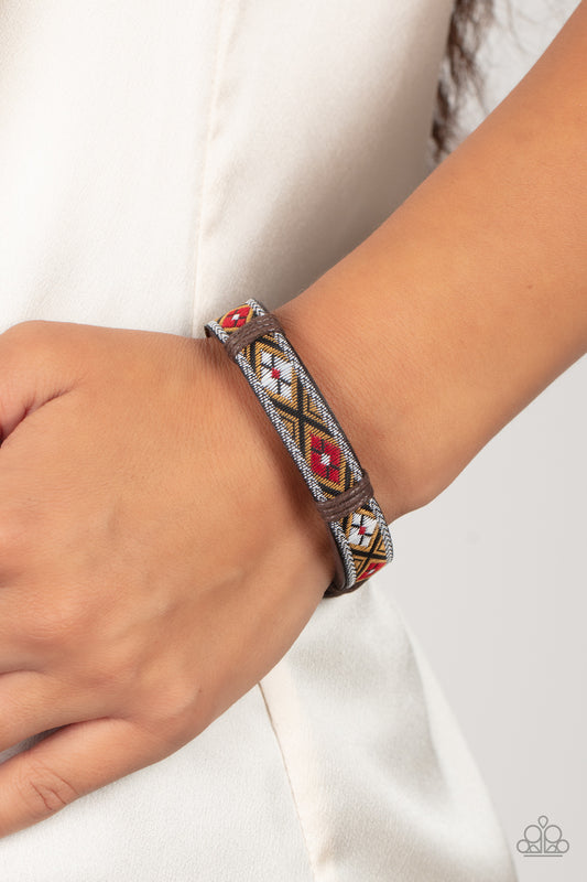 Textile Takeover Red Urban Bracelet - Paparazzi Accessories  A ribbon featuring a floral red, brown, black, and white textile print is knotted in place across the front of a brown leather band, creating a simply seasonal style around the wrist. Features an adjustable sliding knot closure.  Sold as one individual bracelet.