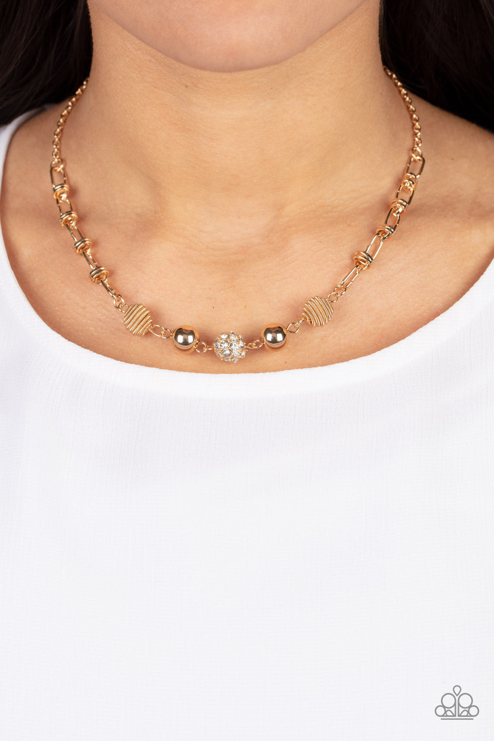 Taunting Twinkle Gold Necklace - Paparazzi Accessories  Pairs of gold coiled and smooth gold beads flank a white rhinestone encrusted bead along an oval and gold disc linked chain, creating a glitzy combination below the collar. Features an adjustable clasp closure.  Sold as one individual necklace. Includes one pair of matching earrings.