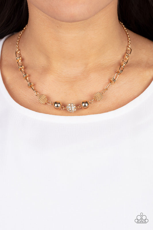 Taunting Twinkle Gold Necklace - Paparazzi Accessories  Pairs of gold coiled and smooth gold beads flank a white rhinestone encrusted bead along an oval and gold disc linked chain, creating a glitzy combination below the collar. Features an adjustable clasp closure.  Sold as one individual necklace. Includes one pair of matching earrings.