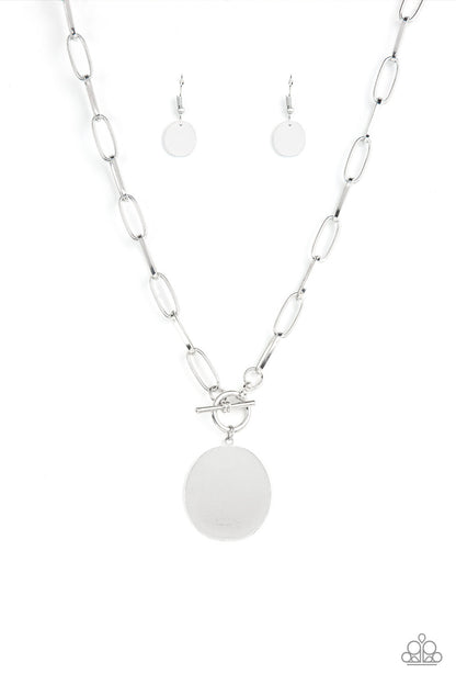 Tag Out Silver Necklace - Paparazzi Accessories  An oversized oval silver disc swings from the bottom of a substantial oval linked silver chain, resulting in a gritty industrial pendant below the collar. Features a toggle closure.  Sold as one individual necklace. Includes one pair of matching earrings.