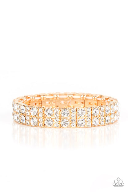 Mic Dropping Drama Gold Bracelet - Paparazzi Accessories  Pairs of glassy white rhinestones and stacked rows of glitzy white rhinestones join into studded gold frames along a stretchy band around the wrist, creating a glamorous centerpiece.  Sold as one individual bracelet.
