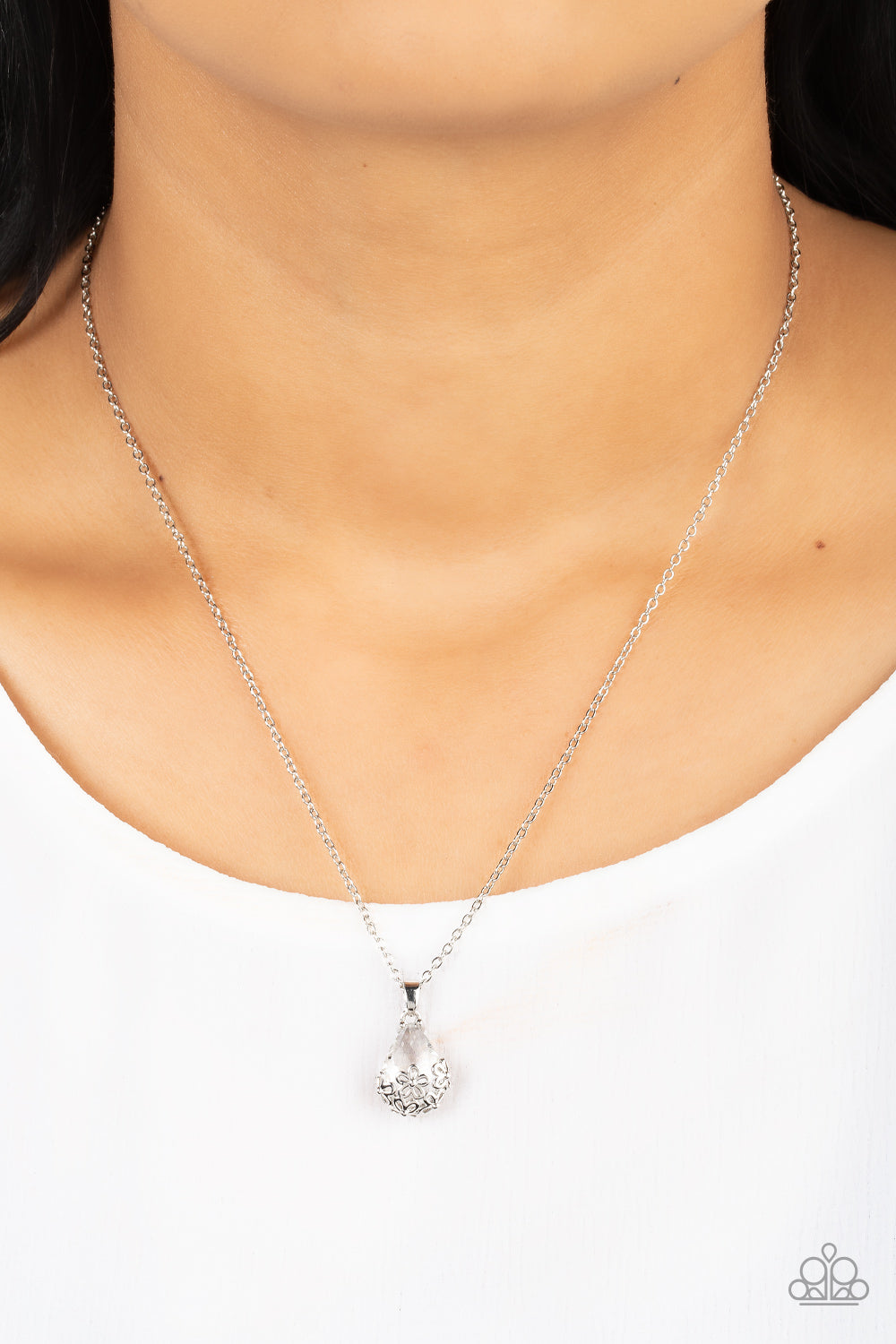 Flower Patch Fabulous White Necklace - Paparazzi Accessories  Dainty silver flowers adorn the bottom of a sparkly white teardrop gem at the bottom of a dainty silver chain, creating a prismatic pendant below the collar. Features an adjustable clasp closure.  Sold as one individual necklace. Includes one pair of matching earrings.