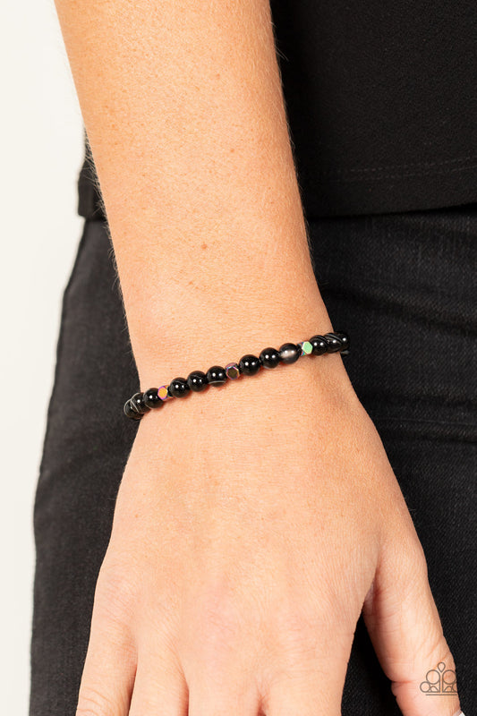 Interstellar Solitude Black Urban Bracelet - Paparazzi Accessories  A dainty collection of natural-finished black stone beads and faceted metallic oil spill cube beads are threaded along a stretchy band around the wrist for an earthy flair.  Sold as one individual bracelet.