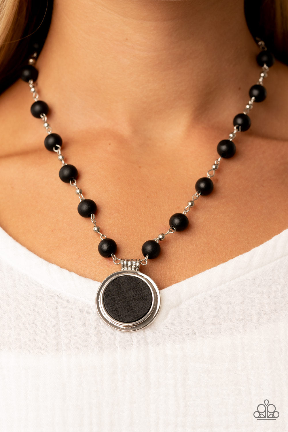Soulful Sunrise Black Necklace - Paparazzi Accessories  Infused with dainty silver chains, a collection of black wooden beads link into an earthy chain below the collar. Featuring a textured silver fitting, a flat black wooden disc is pressed into a silver frame, resulting in a naturally refined pendant. Features an adjustable clasp closure.  Sold as one individual necklace. Includes one pair of matching earrings.