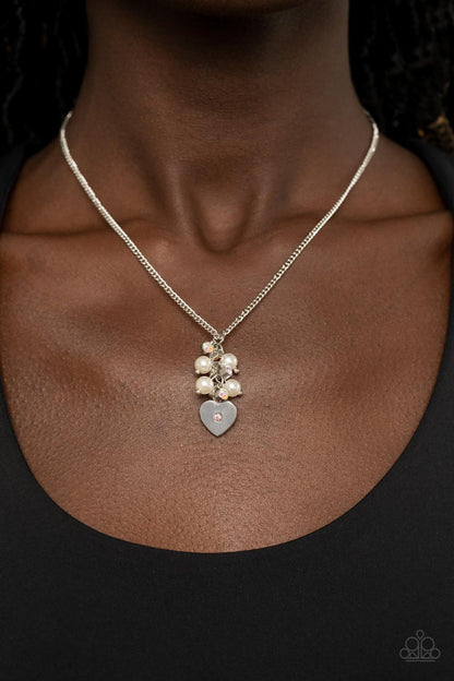 Pop It and LOCKET Multi Necklace - Paparazzi Accessories  Dotted with a dainty iridescent rhinestone, a shiny silver heart swings from the bottom of a bubbly cluster of white pearls and iridescent rhinestones, creating a locket inspired pendant below the collar. Features an adjustable clasp closure.  Sold as one individual necklace. Includes one pair of matching earrings.