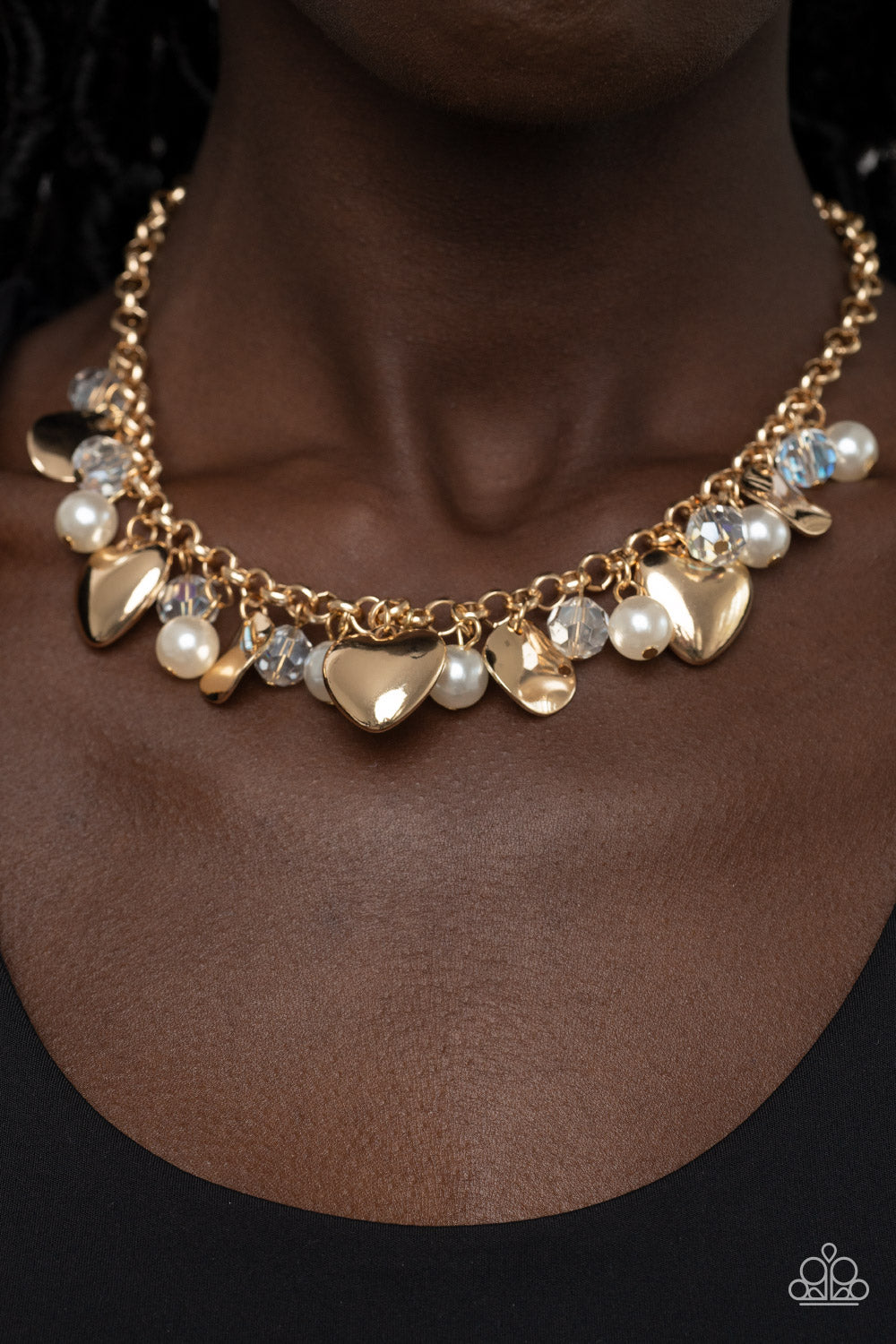True Loves Trove Gold Necklace - Paparazzi Accessories  A flirtatious collection of white pearls, glassy white crystal-like beads, crinkled gold discs, and oversized locket inspired gold heart frames dance from a gold chain, resulting in a romantic fringe below the collar. Features an adjustable clasp closure.  Sold as one individual necklace. Includes one pair of matching earrings.