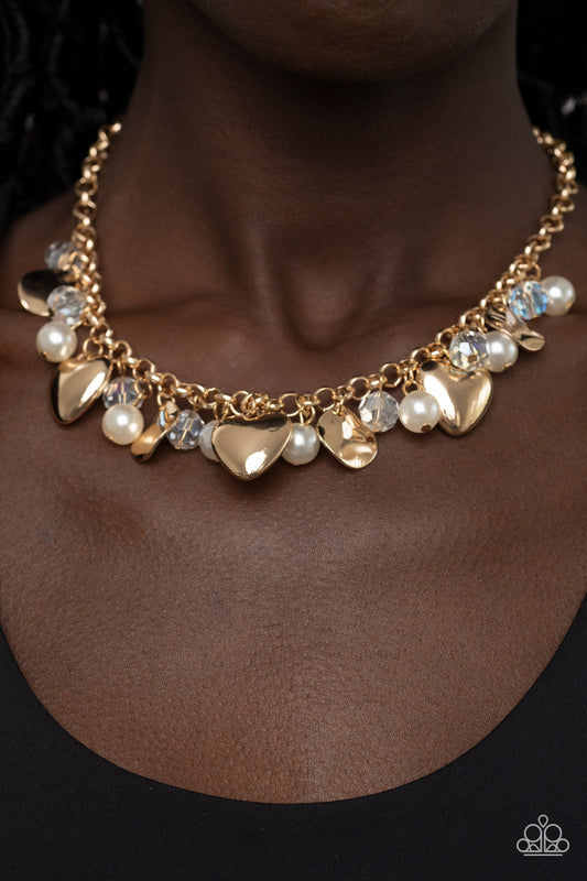 True Loves Trove Gold Necklace - Paparazzi Accessories  A flirtatious collection of white pearls, glassy white crystal-like beads, crinkled gold discs, and oversized locket inspired gold heart frames dance from a gold chain, resulting in a romantic fringe below the collar. Features an adjustable clasp closure.  Sold as one individual necklace. Includes one pair of matching earrings.