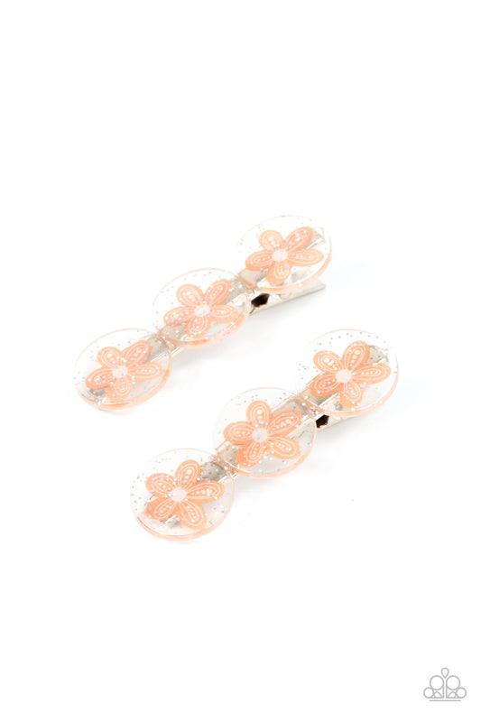 Pamper Me in Posies Orange Hair Clip - Paparazzi Accessories  Sprinkled in silvery sparkles, trios of orange flower adorned acrylic discs join into a whimsical pair of hair clips. Features standard hair clips on the back.  Sold as a set of two hair clips.