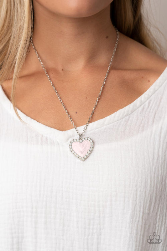 Heart Full of Luster Pink Necklace - Paparazzi Accessories  Bordered in a row of opal white rhinestones, a silver frame is painted in a glossy pink finish at the bottom of a silver chain for a flirtatious finish. Features an adjustable clasp closure.  Sold as one individual necklace. Includes one pair of matching earrings.