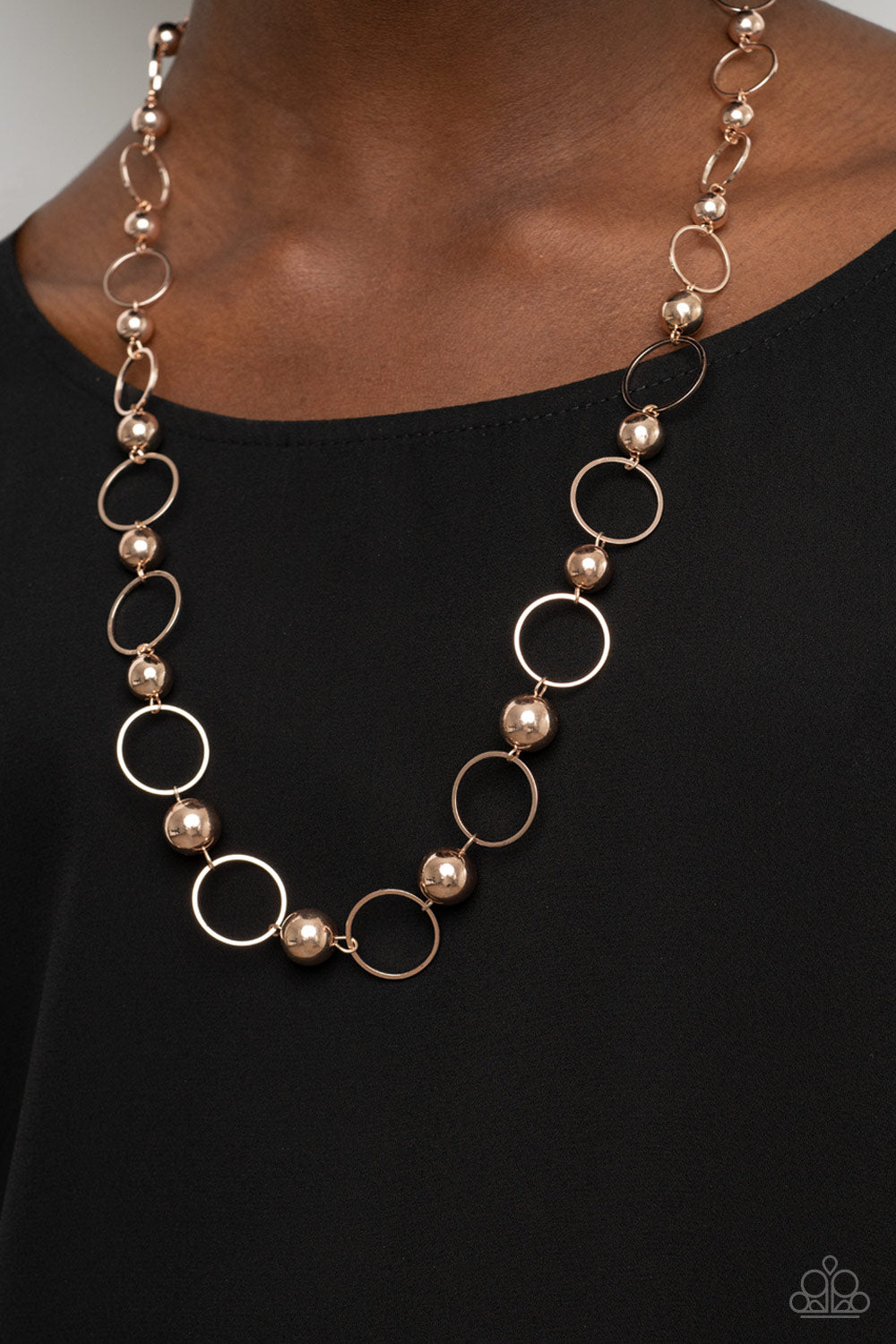 Metro Milestone Rose Gold Necklace - Paparazzi Accessories  Gradually increasing in size, a glistening collection of rose gold beads and rose gold hoops alternate across the chest for a classic metallic fashion. Features an adjustable clasp closure.  Sold as one individual necklace. Includes one pair of matching earrings.