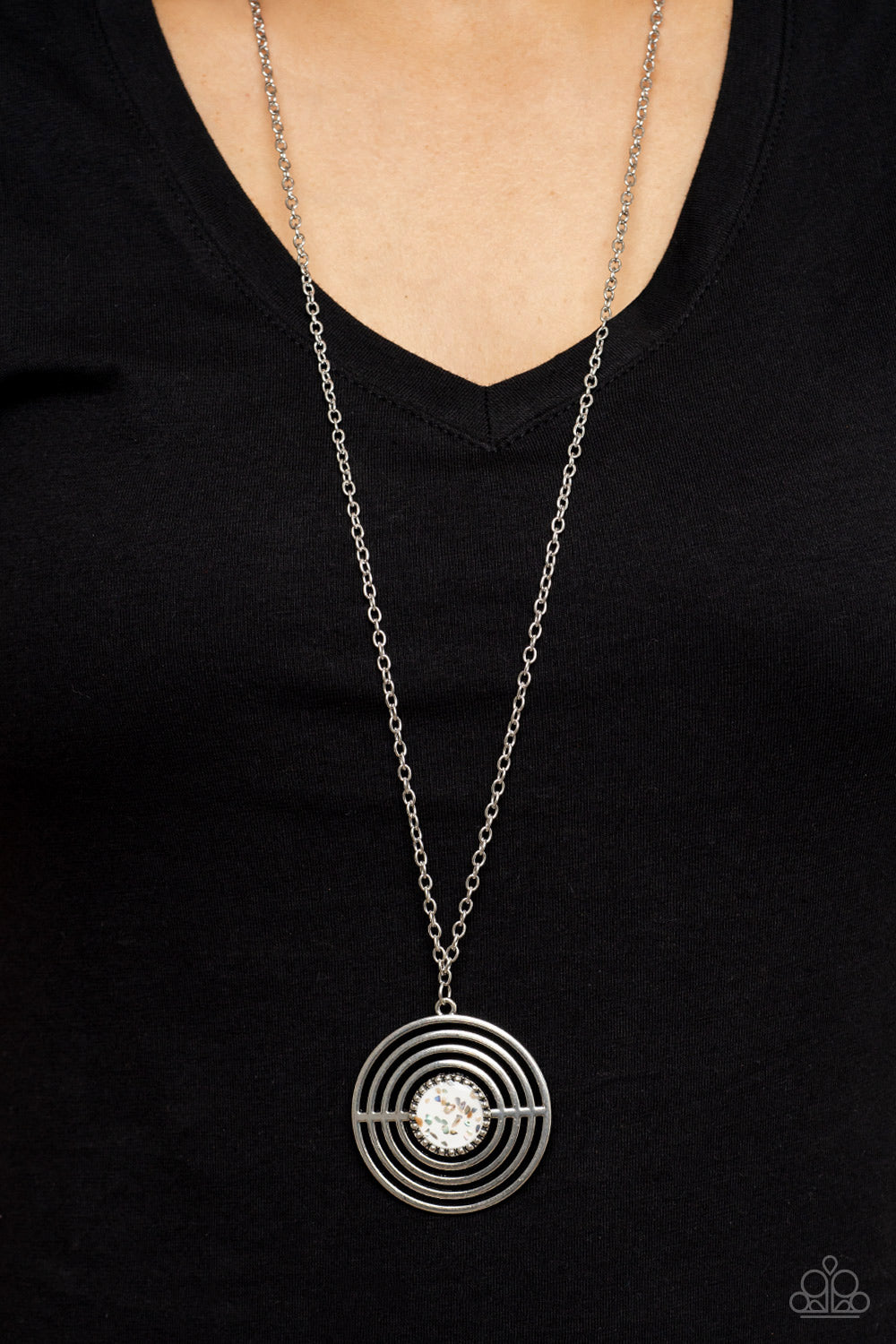 Targeted Tranquility - White Item #P2SE-WTXX-275XX Flecked in iridescent shell-like accents, a studded white frame adorns the center of an oversized silver pendant rippling with concentric circles at the bottom of an extended silver chain for a dizzying pop of color. Features an adjustable clasp closure.  Sold as one individual necklace. Includes one pair of matching earrings.