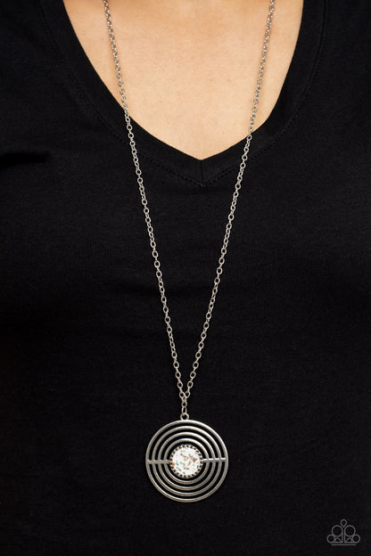 Targeted Tranquility - White Item #P2SE-WTXX-275XX Flecked in iridescent shell-like accents, a studded white frame adorns the center of an oversized silver pendant rippling with concentric circles at the bottom of an extended silver chain for a dizzying pop of color. Features an adjustable clasp closure.  Sold as one individual necklace. Includes one pair of matching earrings.