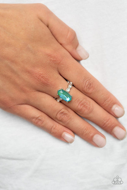 Stellar Sensation Green Ring - Paparazzi Accessories  Featuring a blue UV finish, an iridescent green oval rhinestone is nestled inside a pronged silver frame atop a dainty band of white rhinestones for a stellar fashion. Features a dainty stretchy band for a flexible fit.  Sold as one individual ring.