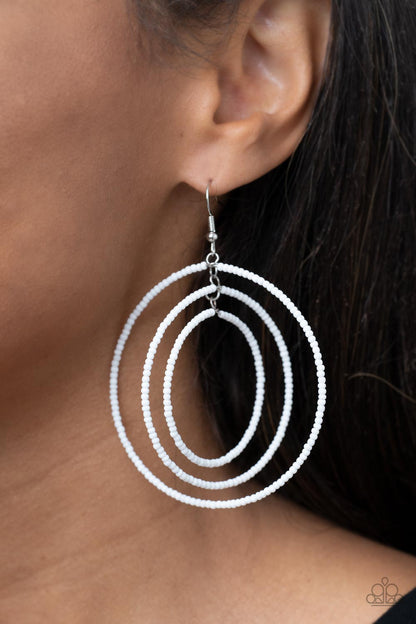 Colorfully Circulating White Earring - Paparazzi Accessories  Three oversized rings of dainty white seed beads ripple into colorfully layered hoops, resulting in a dizzying display. Earring attaches to a standard fishhook fitting.  Sold as one pair of earrings.