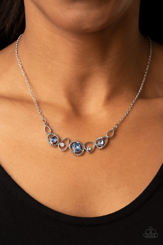 Celestial Cadence Blue Necklace - Paparazzi Accessories  An incandescent assortment of shiny silver frames, dainty white rhinestones, and oversized blue gems delicately coalesce into a statement-making sparkle below the collar. Features an adjustable clasp closure.  Sold as one individual necklace. Includes one pair of matching earrings.