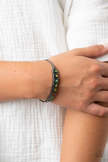 Vertigo Views Multi Cuff Bracelet - Paparazzi Accessories  A frame of oversized oil spill rhinestones is set atop a dainty gunmetal cuff featuring gunmetal beaded fittings, resulting in a stellar and stackable centerpiece.  Sold as one individual bracelet.