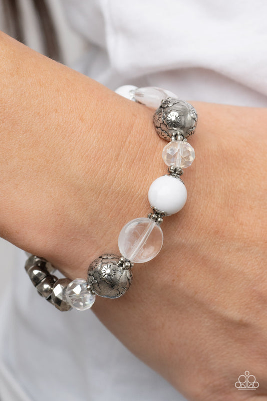 Pretty Persuasion White Bracelet - Paparazzi Accessories  An enchanting assortment of silver floral beads and studded silver rings join an opaque, glassy, and iridescent assortment of white beads along a stretchy band around the wrist for a whimsical pop of color.  Sold as one individual bracelet.