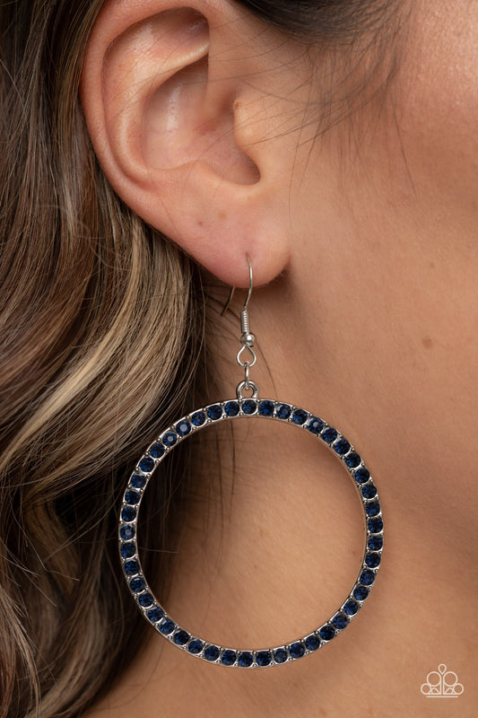 Head-Turning Halo Blue Earring - Paparazzi Accessories  The front of an oversized silver ring is encrusted in glitzy blue rhinestones, resulting in a head-turning hoop. Earring attaches to a standard fishhook fitting.  Sold as one pair of earrings.