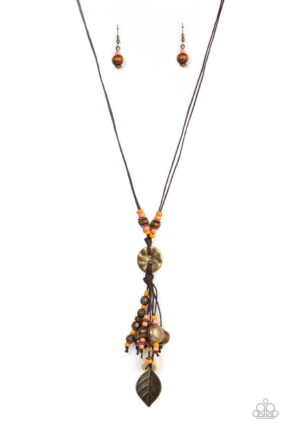 Knotted Keepsake Orange Necklace - Paparazzi Accessories  An earthy assortment of orange and coral seed beads, rustic brass discs, and wooden accents glide along lengthy strands of brown cording that knot around a hammered brass disc. Tassels of matching beads, a white shell-like accent, floral silver bead, and brass leaf charm dance from the bottom, adding playful movement to the free-spirited display. Features an adjustable clasp closure. Includes one pair of matching earrings.