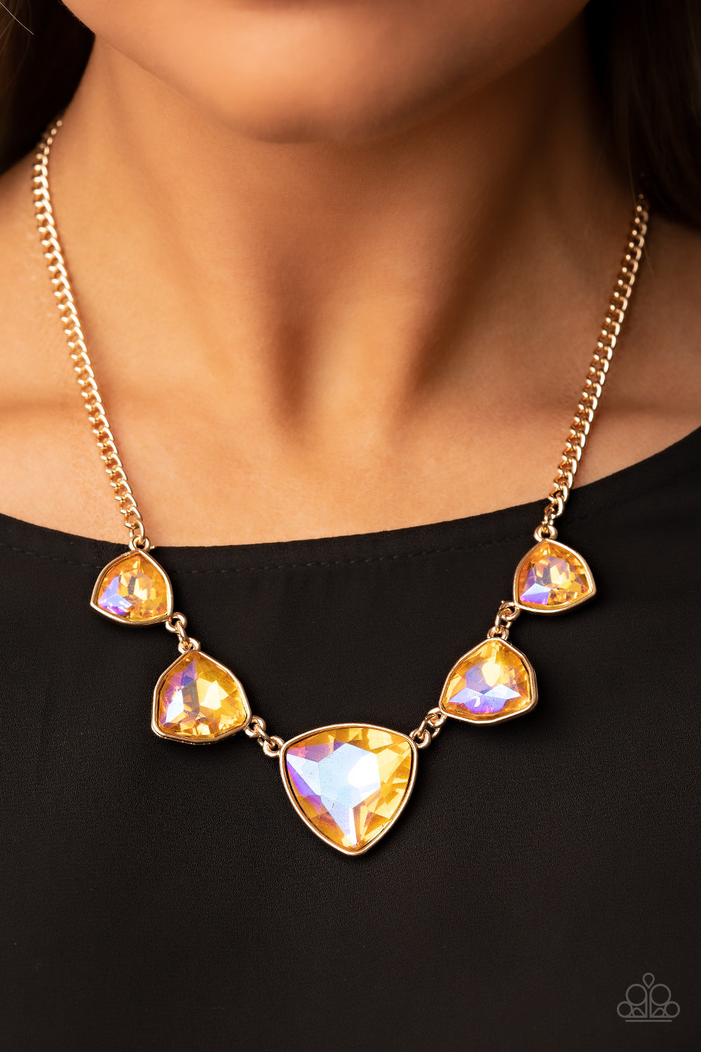 Cosmic Constellations Gold Necklace - Paparazzi Accessories  Encased in sleek gold fittings, an oversized collection of UV geometric gems gradually increase in size as they link below the collar for a golden statement. Features an adjustable clasp closure.  Sold as one individual necklace. Includes one pair of matching earrings.