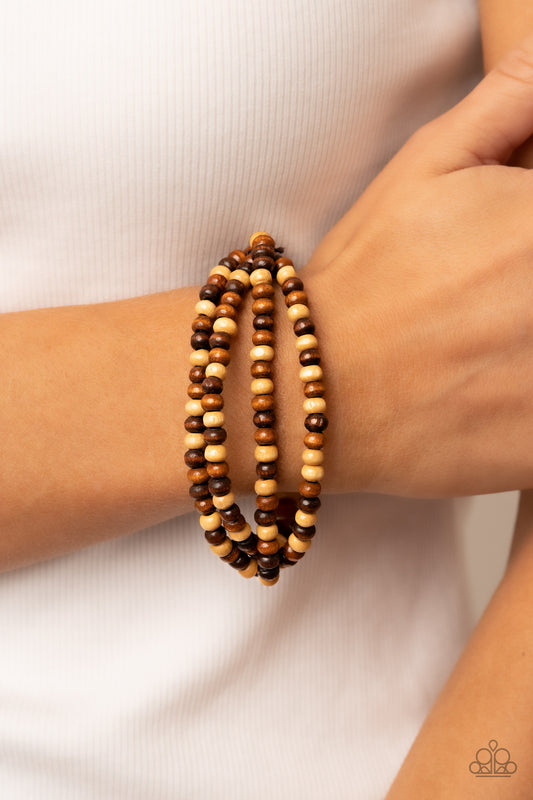 Oceania Oasis Brown Bracelet - Paparazzi Accessories  Varying in natural wooden finishes, stretchy strands of dainty wooden beads attach to a single row of oversized wooden beads around the wrist for an earthy spin on the homespun trend.  Sold as one individual bracelet.