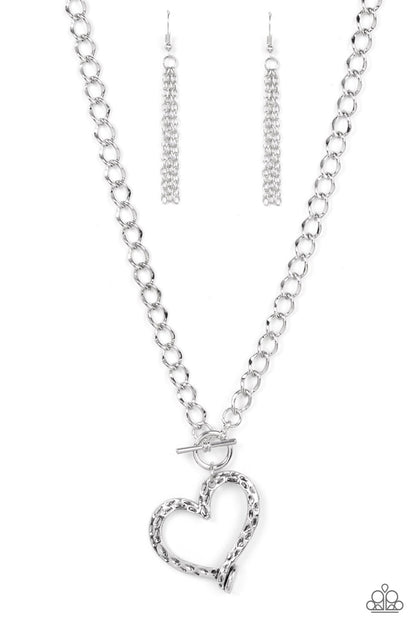 Reimagined Romance Silver Toggle Necklace - Paparazzi Accessories  A hammered silver heart frame gently twists from a toggle closure at the bottom of a chunky silver chain, resulting in a romantically rustic pendant. Features a toggle closure.  Sold as one individual necklace. Includes one pair of matching earrings.