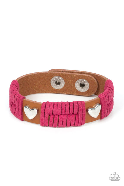 Lusting for Wanderlust Pink Bracelet - Paparazzi Accessories  Sections of pink suede laces wrap around spliced sections of a brown leather band. A pair of silver heart frames stud the front of the band, adding romantic charm to the rustic centerpiece. Features an adjustable snap closure.  Sold as one individual bracelet.