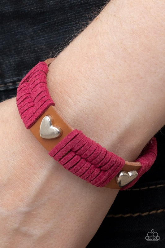 Lusting for Wanderlust Pink Bracelet - Paparazzi Accessories  Sections of pink suede laces wrap around spliced sections of a brown leather band. A pair of silver heart frames stud the front of the band, adding romantic charm to the rustic centerpiece. Features an adjustable snap closure.  Sold as one individual bracelet.
