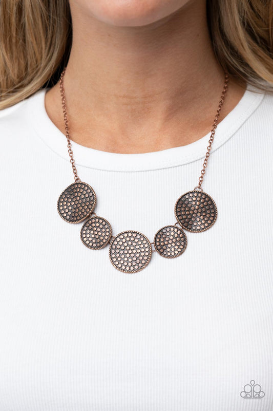 Self DISC-overy Copper Necklace - Paparazzi Accessories  Embossed in a dotted motif, a rustic collection of warped copper discs ruggedly links below the collar for an artisan inspired fashion. Features an adjustable clasp closure.  Sold as one individual necklace. Includes one pair of matching earrings.