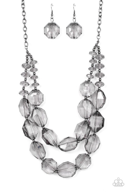 Icy Illumination Black Necklace - Paparazzi Accessories  Separated by dainty silver beads, an icy collection of oversized and faceted smoky gems are threaded along invisible wires below the collar, resulting in prismatic layers. Features an adjustable clasp closure.  Sold as one individual necklace. Includes one pair of matching earrings.