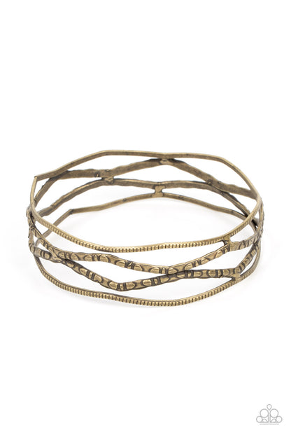 A Narrow ESCAPADE - Brass Item #P9BA-BRXX-059XX Textured and embossed in nature inspired patterns, rustic brass bars zigzag around the wrist as they stack into a wildly layered bangle.  Sold as one individual bracelet.