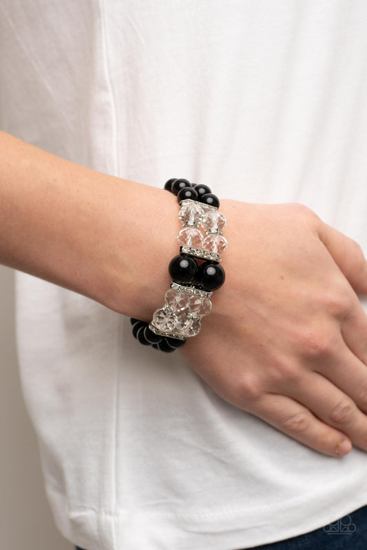 Timelessly Tea Party Black Bracelet - Paparazzi Accessories  Held together by white rhinestone encrusted silver frames, a stretchy pair of bubbly black beaded bracelets are infused with white rhinestone encrusted silver rings, iridescent crystal-like beads, and oversized black beads for a timeless finish.  Sold as one individual bracelet.