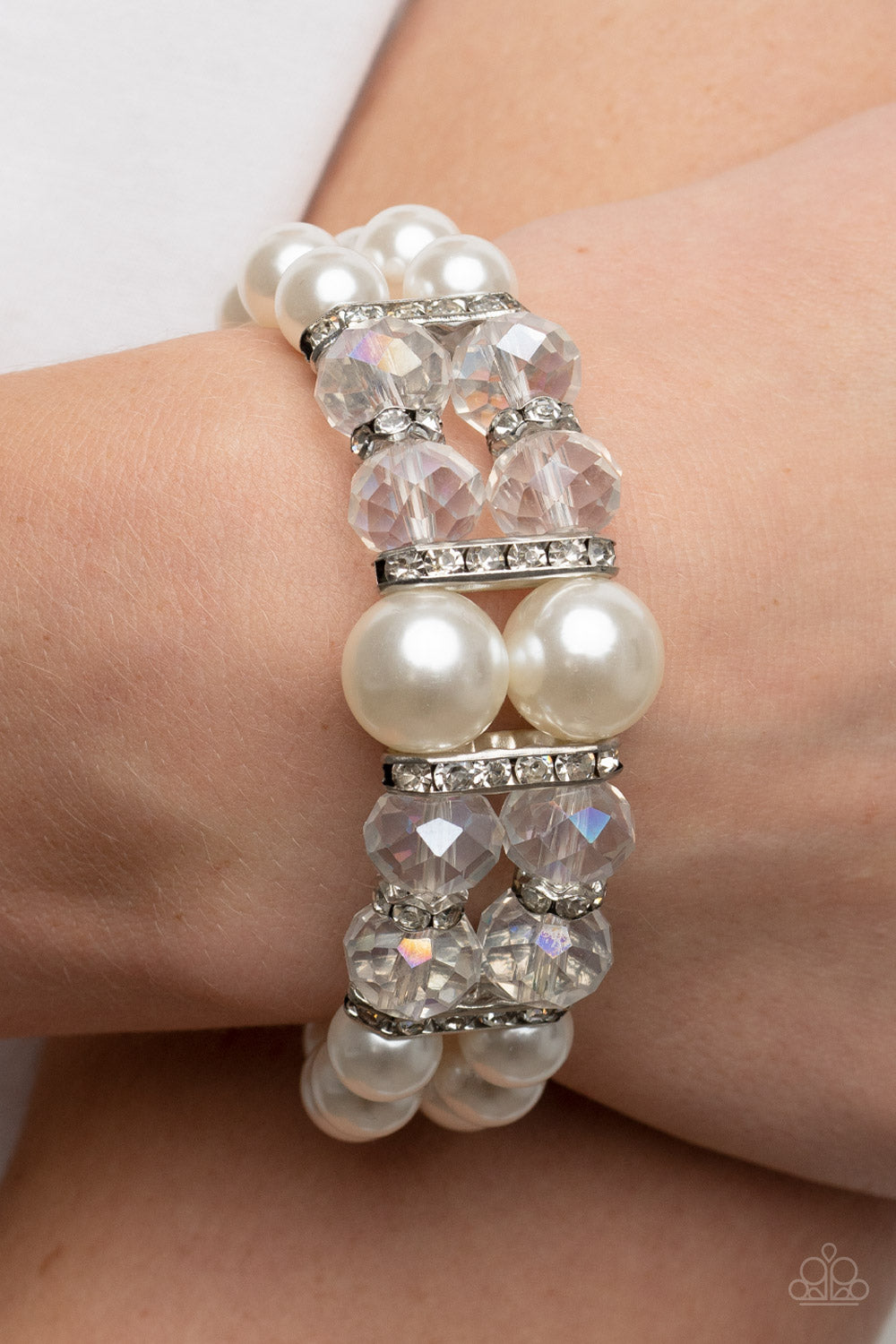 Timelessly Tea Party White Bracelet - Paparazzi Accessories  Held together by white rhinestone encrusted silver frames, a stretchy pair of bubbly pearl bracelets are infused with white rhinestone encrusted silver rings, iridescent crystal-like beads, and oversized white pearls for a timeless finish.  Sold as one individual bracelet.