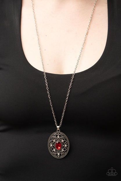 Sonata Swing - Red Item #P2RE-RDXX-234XX Dainty white rhinestones are sprinkled across silver vine-like filigree that whirls around an oval red gem center inside of a studded silver frame, resulting in a whimsical pendant at the bottom of a silver chain. Features an adjustable clasp closure.  Sold as one individual necklace. Includes one pair of matching earrings.