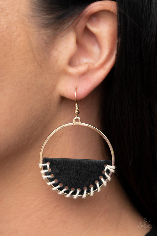 Lavishly Laid Back Black Earring - Paparazzi Accessories  White cording is threaded through the bottom of a half moon piece of black leather, anchoring the earthy accent in place inside a glistening gold hoop for an earthy flair. Earring attaches to a standard fishhook fitting.  Featured inside The Preview at GLOW!  Sold as one pair of earrings.