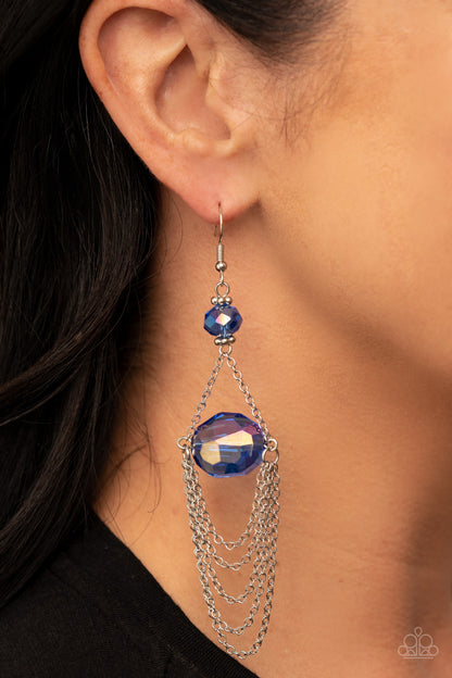 Ethereally Extravagant Blue Earring - Paparazzi Accessories  Tiers of dainty silver chains delicately layer from an oversized oval iridescent blue gem that is suspended from a faceted matching blue crystal-like bead, resulting in an ethereal chandelier. Earring attaches to a standard fishhook fitting.  Sold as one pair of earrings.