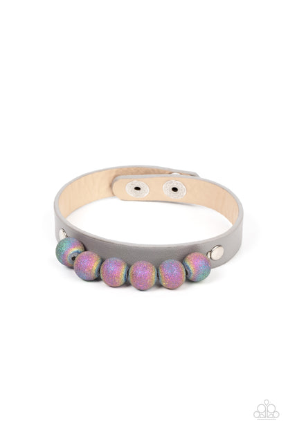 Saturn Safari Silver Wrap Bracelet - Paparazzi Accessories  Brushed in shimmering glitter, multicolored beads swirling in an oil spill finish are threaded along a wire. The colorful collection is layered atop an Ultimate Gray leather band for an out-of-this-world finish. Features an adjustable snap closure.  Sold as one individual bracelet.
