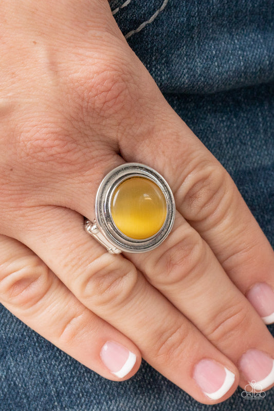 Laguna Luminosity Yellow Ring - Paparazzi Accessories  A yellow cat's eye stone is encircled in rippling silver frames, pooling into an ethereal pop of color atop the finger. Features a stretchy band for a flexible fit.  Sold as one individual ring.