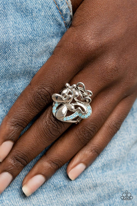 Fluttering Flashback Blue Ring - Paparazzi Accessories  Enhanced with blue opal rhinestones, a shiny collection of mismatched silver butterfly frames flutters atop the finger, resulting in a whimsical bouquet. Features a stretchy band for a flexible fit.  Sold as one individual ring.