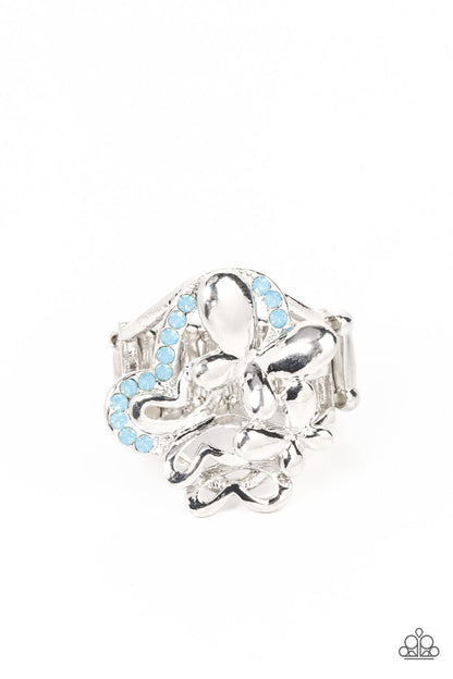 Fluttering Flashback Blue Ring - Paparazzi Accessories  Enhanced with blue opal rhinestones, a shiny collection of mismatched silver butterfly frames flutters atop the finger, resulting in a whimsical bouquet. Features a stretchy band for a flexible fit.  Sold as one individual ring.